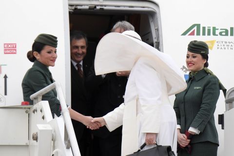 Francis shakes hands with Alitalia crew members before departing Rome on April 28.