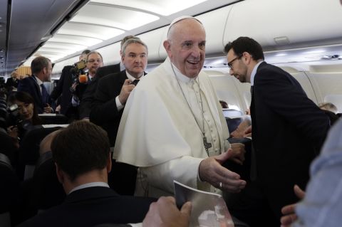 The Pope greets journalists on the airplane en route to Egypt.