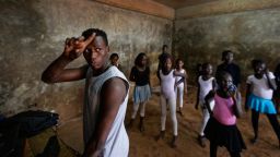 In this photo taken Friday, Dec. 9, 2016, young ballerinas practice under the instruction of Kenyan ballet dancer Joel Kioko, 16, left, in a room at a school in the Kibera slum of Nairobi, Kenya. In a country not usually associated with classical ballet, Kenya's most promising young ballet dancer Joel Kioko has come home for Christmas from his training in the United States, to dance a solo in The Nutcracker and teach holiday classes to aspiring dancers in Kibera, the Kenyan capital's largest slum. (AP Photo/Ben Curtis)
