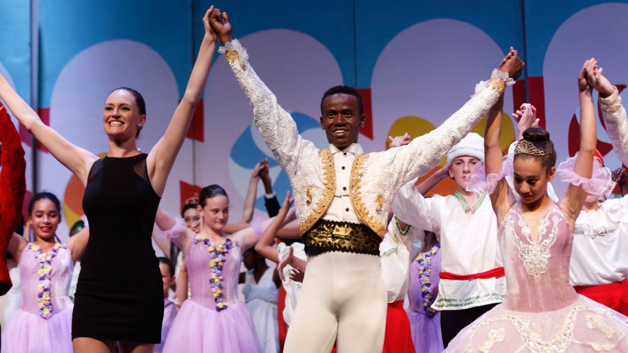 In this photo taken Friday, Dec. 9, 2016, Dance Centre Kenya's artistic director Cooper Rust, left, from the United States, holds the hand of Kenyan ballet dancer Joel Kioko, 16, center, as they take a bow at the end of a performance of The Nutcracker in Nairobi, Kenya. In a country not usually associated with classical ballet, Kenya's most promising young ballet dancer Joel Kioko has come home for Christmas from his training in the United States, to dance a solo in The Nutcracker and teach holiday classes to aspiring dancers in Kibera, the Kenyan capital's largest slum. (AP Photo/Ben Curtis)