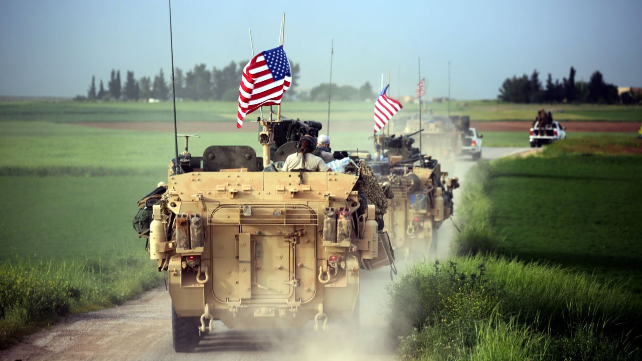 TOPSHOT - US forces, accompanied by Kurdish People's Protection Units (YPG) fighters, drive their armoured vehicles near the northern Syrian village of Darbasiyah, on the border with Turkey on April 28, 2017. / AFP PHOTO / DELIL SOULEIMAN        (Photo credit should read DELIL SOULEIMAN/AFP/Getty Images)