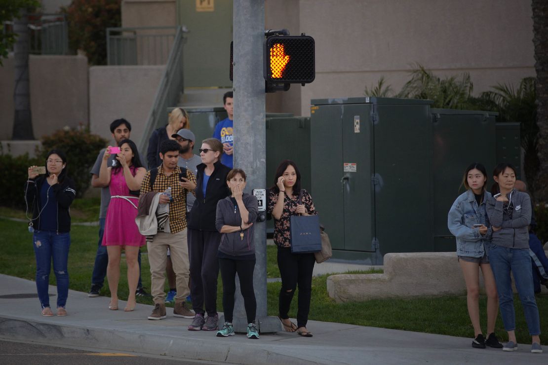 A crowd gathers outside the La Jolla Crossroads apartments in San Diego.