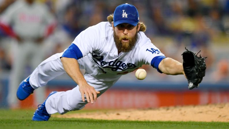 Josh Fields, a relief pitcher for the Los Angeles Dodgers, dives for a ball during a game against Philadelphia on Friday, April 28.