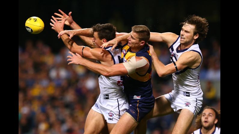 Players compete for the ball during an Australian Football League match in Perth on Saturday, April 29. From left are Fremantle's Ethan Hughes, West Coast's Nathan Vardy and Fremantle's Joel Hamling.