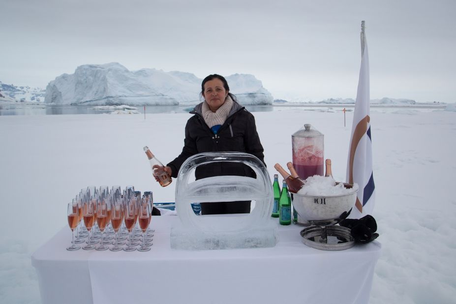 Previous expeditions have incldued Greenland and Antarctica -- where a member of The World's staff is pictured serving champagne on ice.