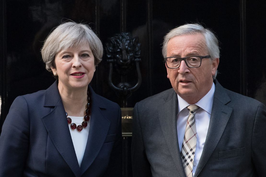 Theresa May stands with European Commission president, Jean-Claude Juncker at the front door of 10 Downing Street in London.