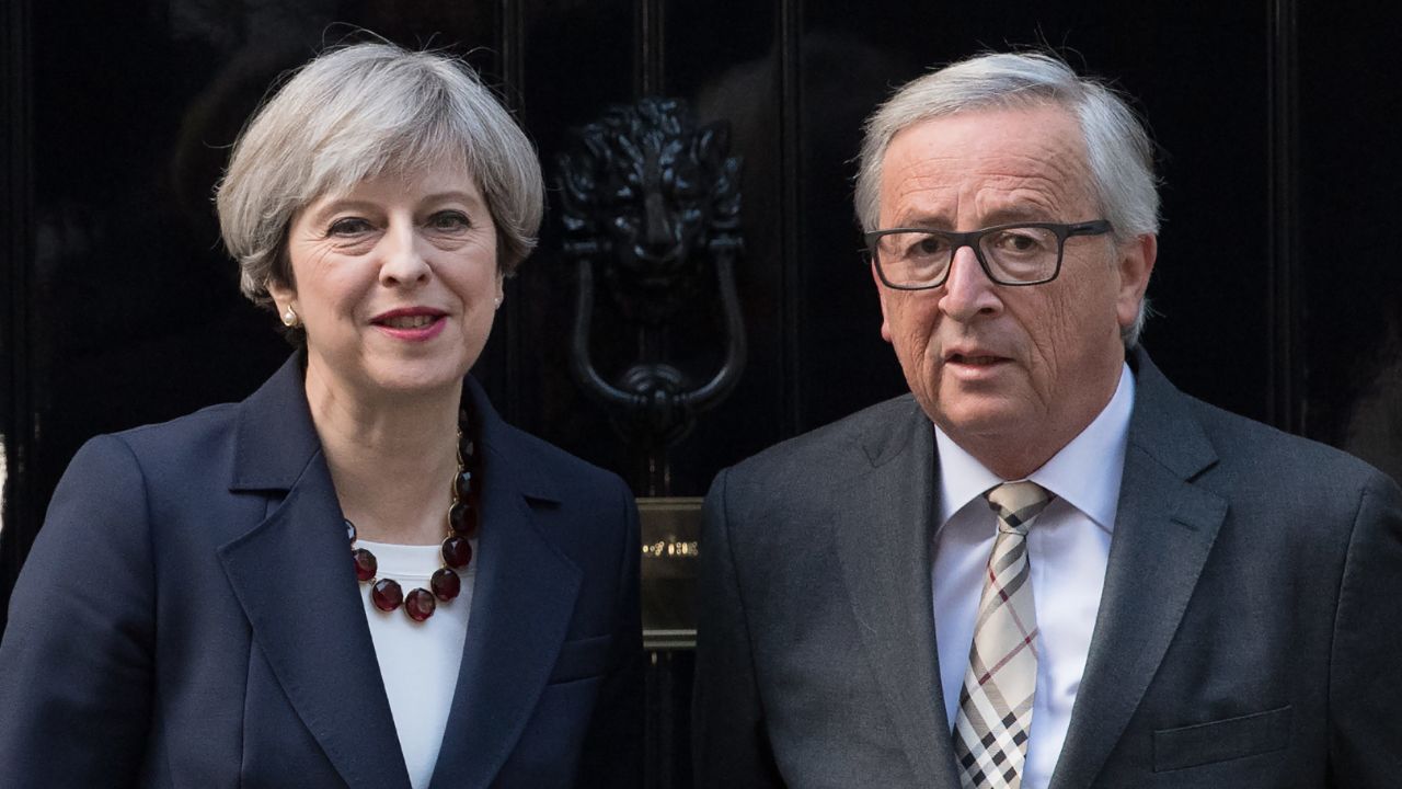 Theresa May stands with European Commission president, Jean-Claude Juncker at the front door of 10 Downing Street in London.