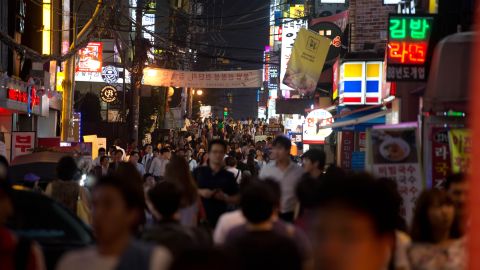 People walk past bars and restaurants on a street in the Gangnam district of Seoul on July 5, 2013. One of Asia's most affluent countries, South Korea is the region's third largest economy fuelled by the longest working hours in the world, according to a 2012 study. However the number of foreign workers in the the country is expected to swell as migrants fill the jobs that increasingly considered as the '3d's'; dirty, dangerous and difficult, or demeaning -- mainly in manufacturing and construction. AFP PHOTO / Ed Jones        (Photo credit should read Ed Jones/AFP/Getty Images)