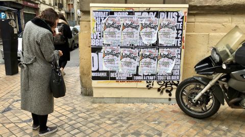 A woman in Bordeaux reads posters urging voters not to turn out this weekend.
