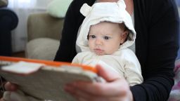 A two month old baby girl watches an interactive app for babies on an iPad while held by her mother. Photo Tim Clayton (Photo by Tim Clayton/Corbis via Getty Images)