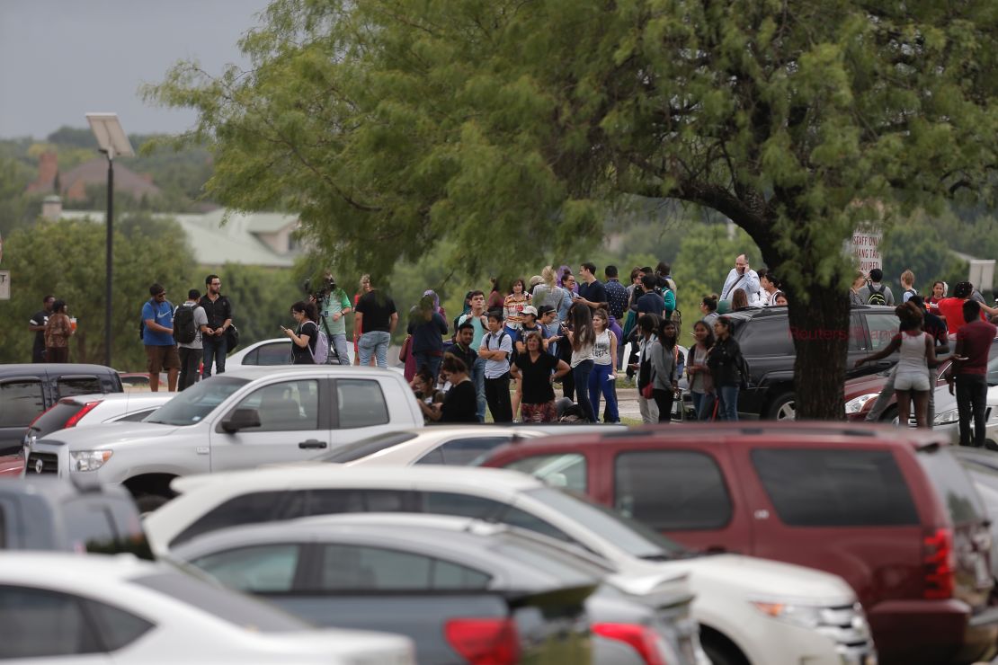 Students gather outside a building at North Lake College in Irving, Texas, after a shooting.