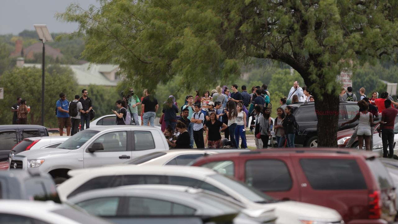 Students gather outside a building at North Lake College in Irving, Texas, after a shooting.