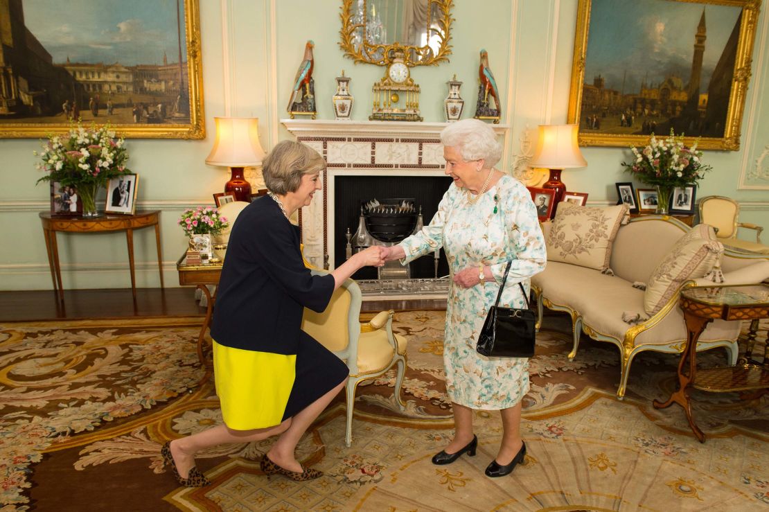 British Prime Minister  Theresa May curtsies to the Queen.  