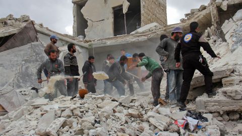 Rescuers and civilians view damage in a village on the outskirts of Idlib after November airstrikes.