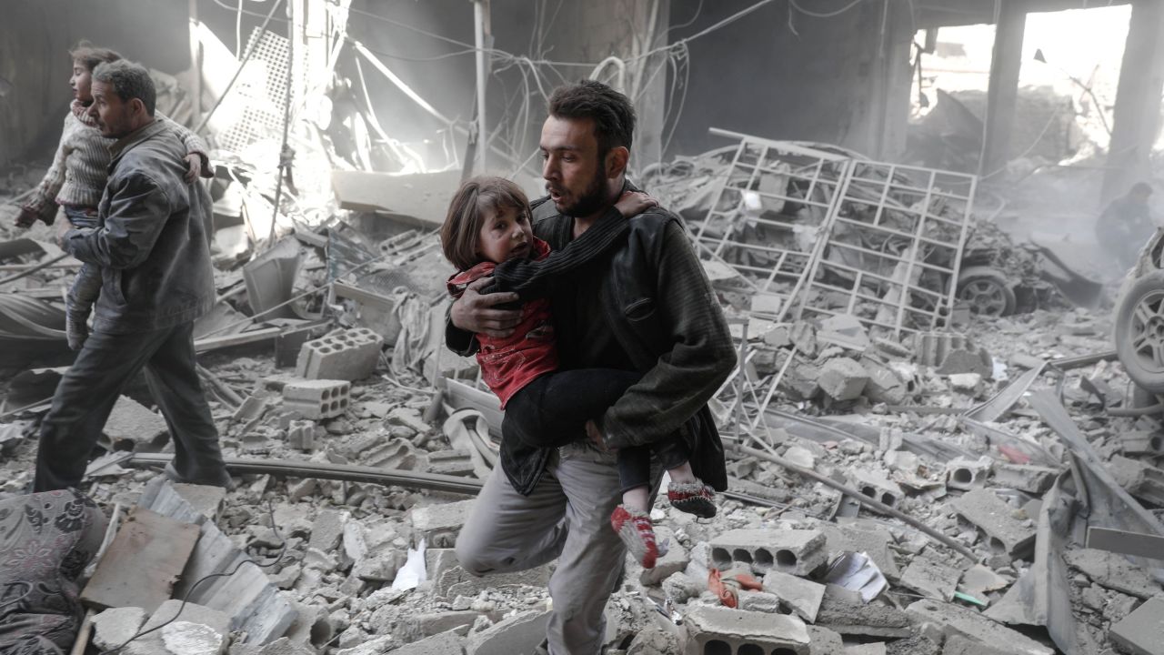 Syrians evacuate children from rubble after February airstrikes on the rebel-held town of Douma.