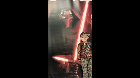 Callan poses in a Chewbacca jacket with a poster of his favorite character, Kylo Ren.