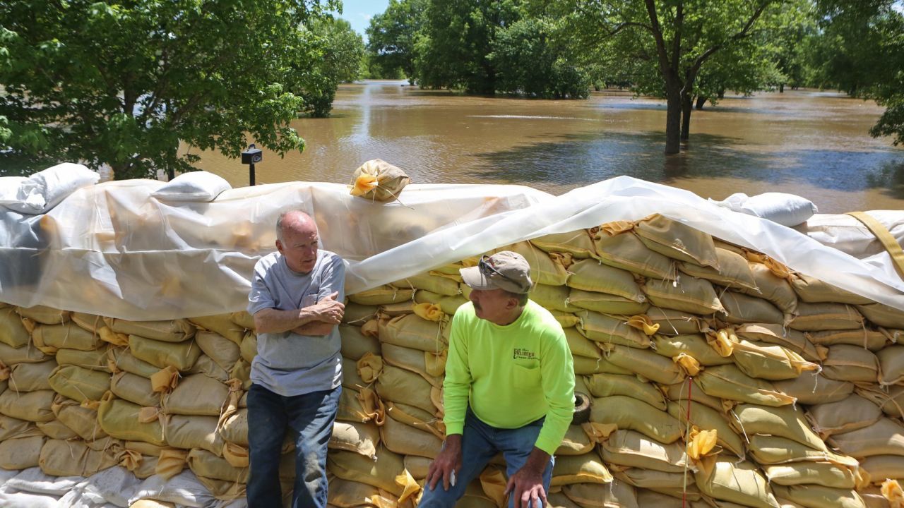 Homeowner Tom Bell, 71, left, and his friend Stan Erlinger take a break from sandbagging and flood preparation on Tuesday in Fenton, Missouri.