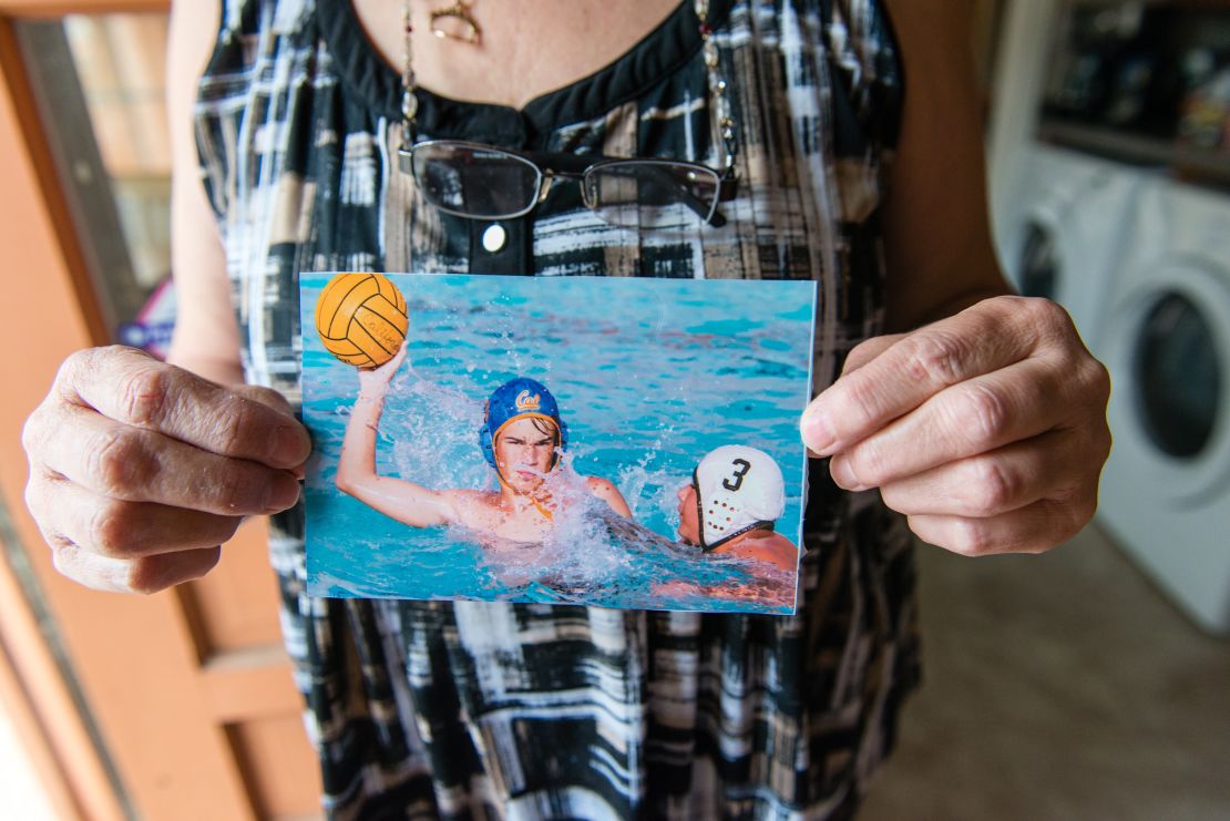 Lynn Whittaker holds an old photograph of her son playing water polo.