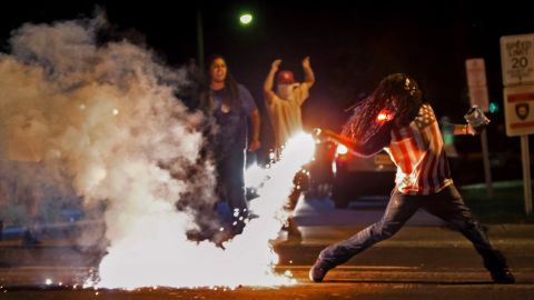 This Aug. 13, 2014, photo by St. Louis Post Dispatch photographer Robert Cohen shows Edward Crawford returning a tear gas canister fired by police who were trying to disperse protesters in Ferguson, Missouri.  Four days earlier, unarmed black teenager Michael Brown was shot to death by white police officer Darren Wilson. The killing ignited riots and unrest in the St. Louis area and across the nation. Cohen and members of the St. Louis Post Dispatch photo staff are winners of the 2015 Pulitzer Prize for Breaking News Photography it was announced Monday, April 20, 2015, at Columbia University in New York.