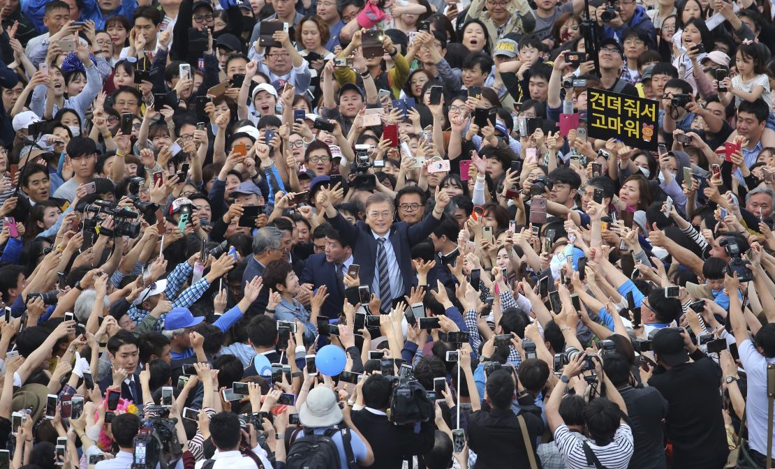 South Korea's presidential candidate Moon Jae-in, center raises his hands during a presidential election campaign in Goyang, South Korea.