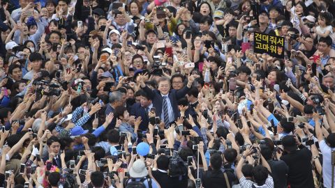 South Korea's presidential candidate Moon Jae-in, center raises his hands during a presidential election campaign in Goyang, South Korea.