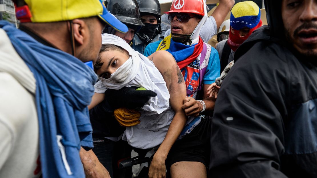 Yaminne is carried away from the protest.