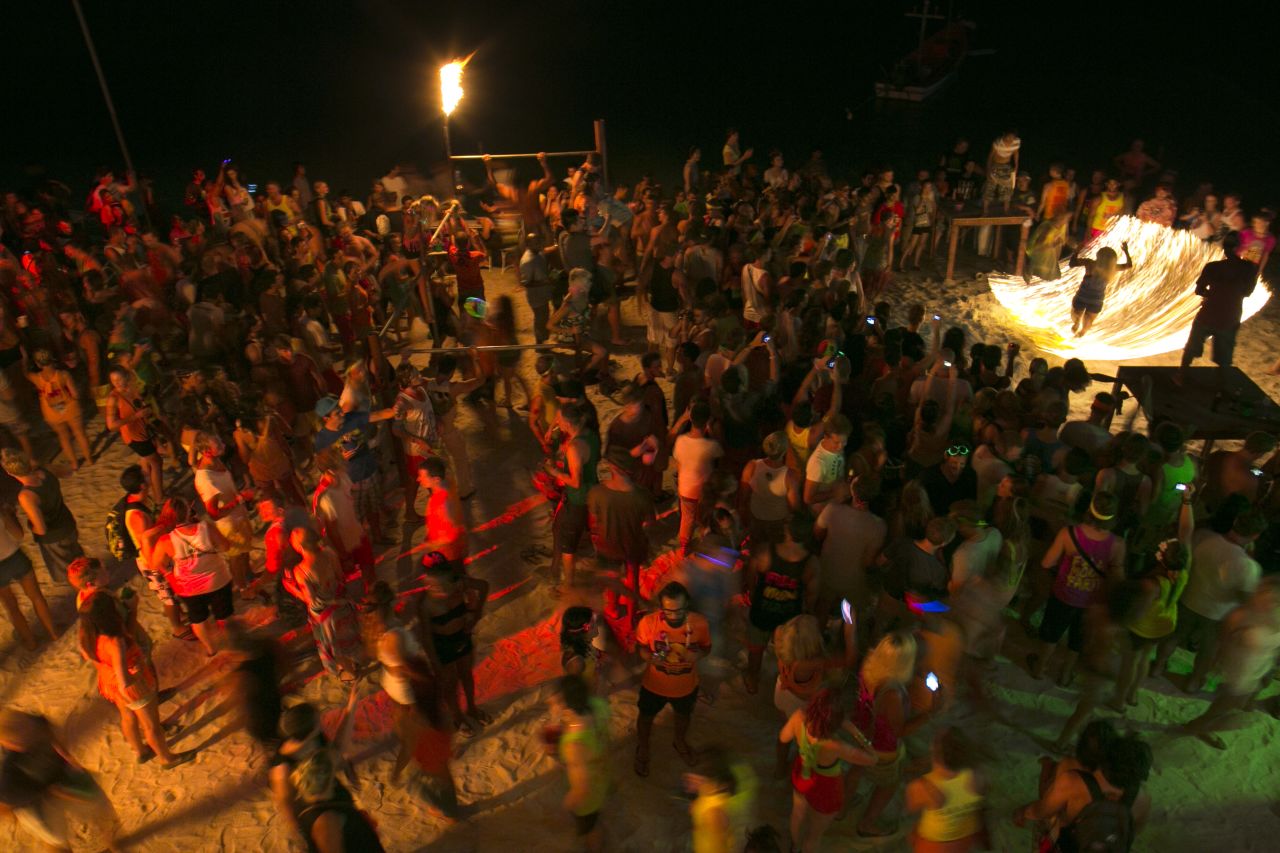 Full moon partiers dance the night away on the beach of Haad Rin.
