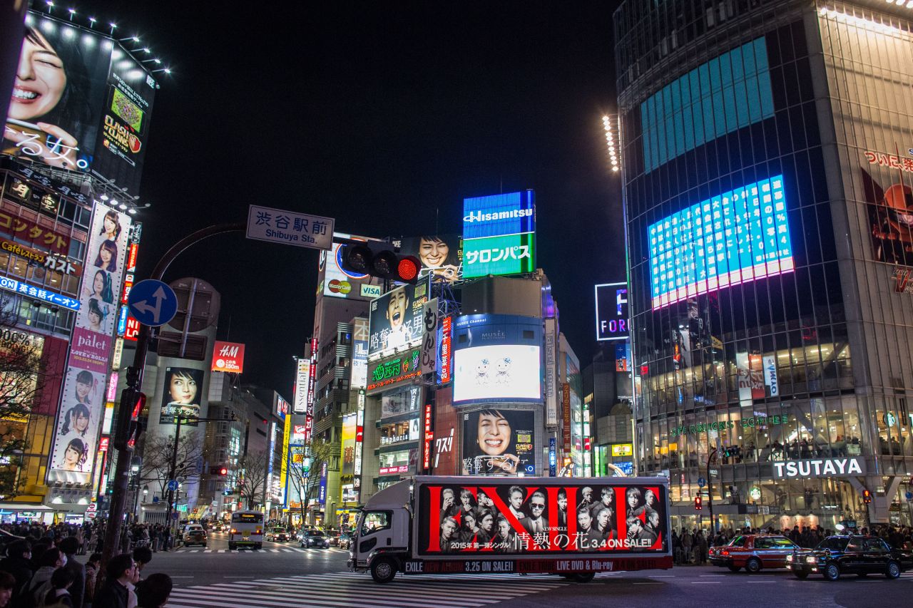 The famous Shibuya intersection lit up with neon at night.