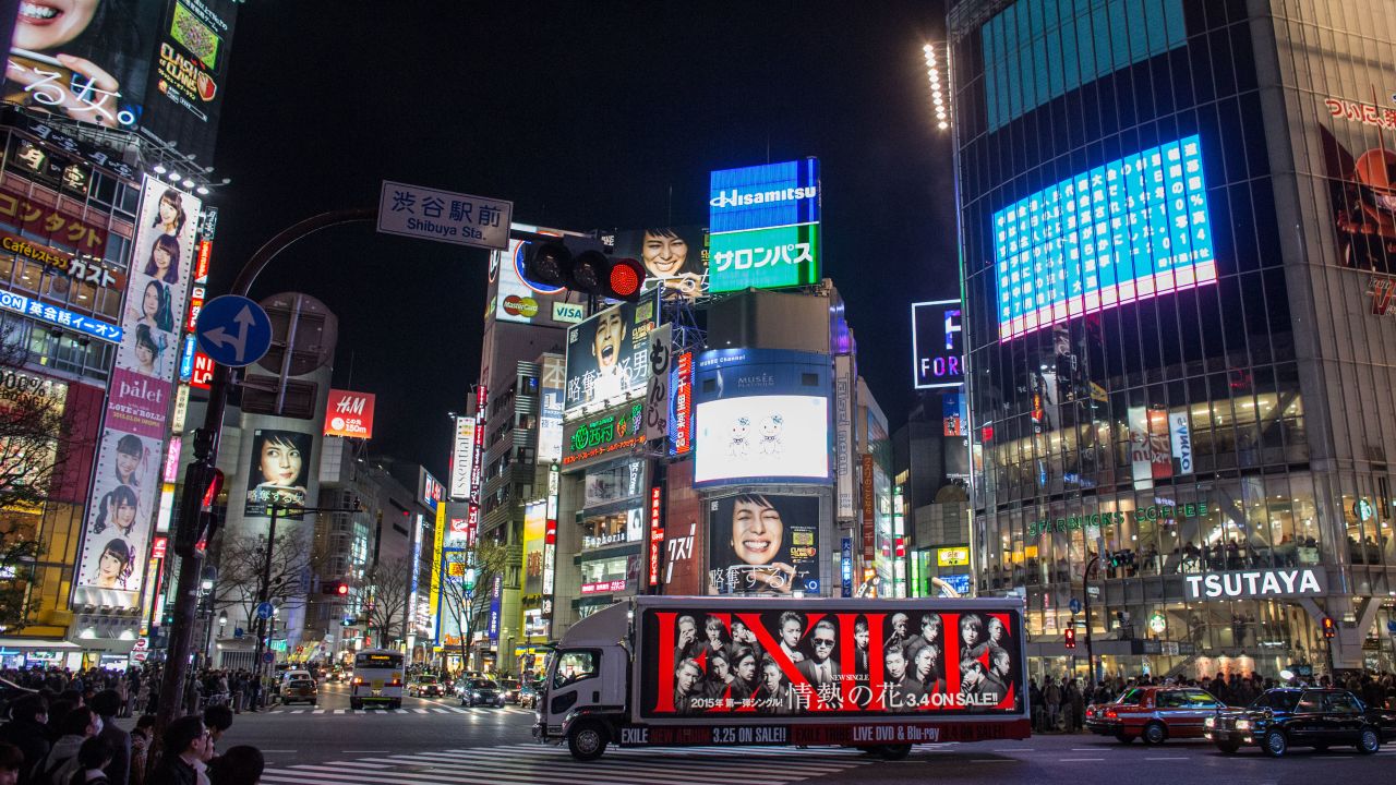 The famous Shibuya intersection lit up with neon at night.