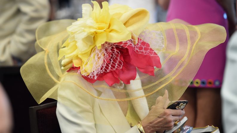 A derby attendee is concealed by the brim of her hat.