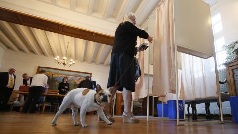 A woman enters a voting booth in Saint Jean de Luz, France, Sunday, May 7.