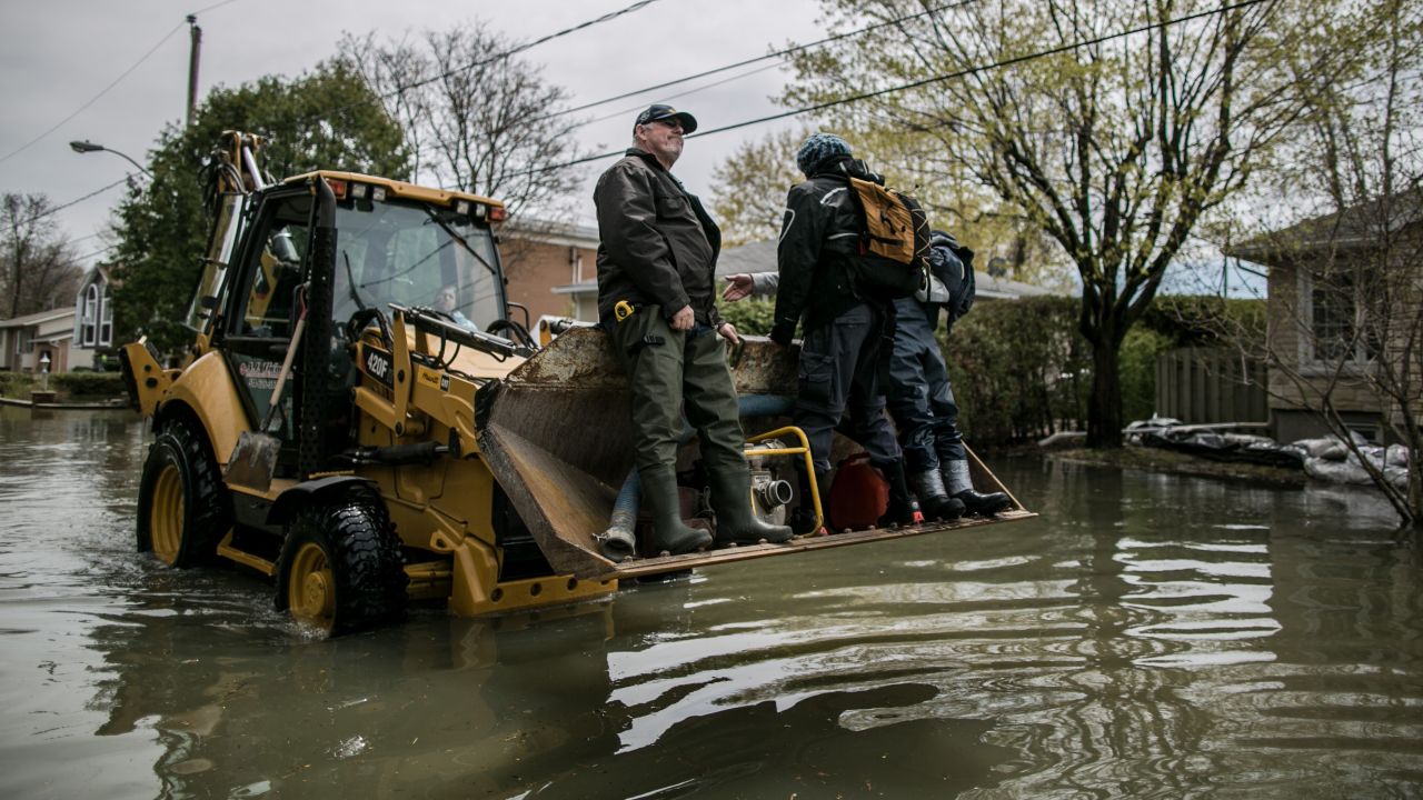 Residents of Mercier Island carry a pump with a tractor on May 6.