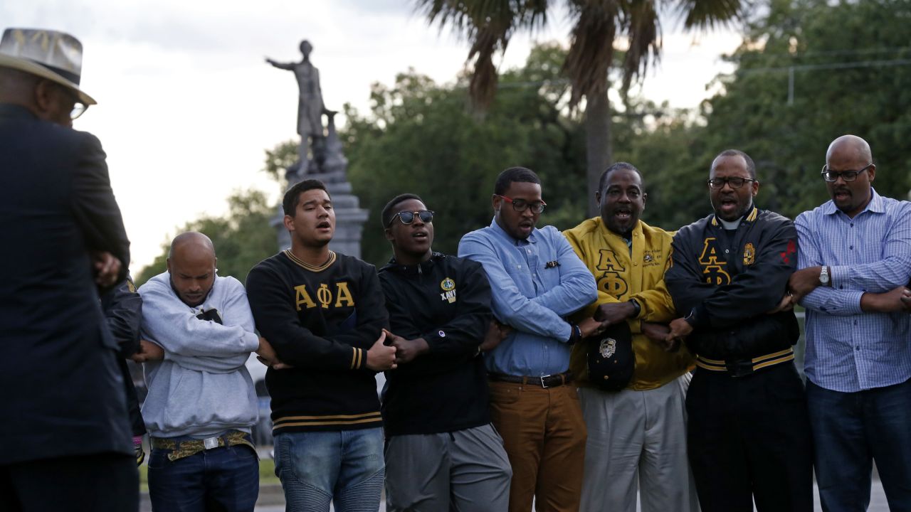 Graduate members of Alpha Phi Alpha Fraternity pray near the Jefferson Davis monument last week.