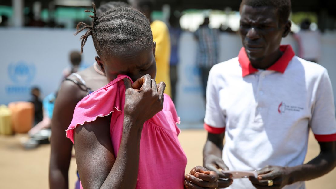 Pastor Fabian Richard Wani tries to help a young woman whose mattress was stolen. Wani fled after his congregation was attacked. "Even church leaders, we weren't safe," he says.