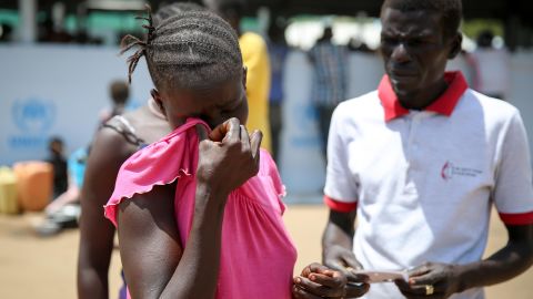 Pastor Fabian Richard Wani tries to help a young woman whose mattress was stolen. Wani fled after his congregation was attacked. "Even church leaders, we weren't safe," he says.
