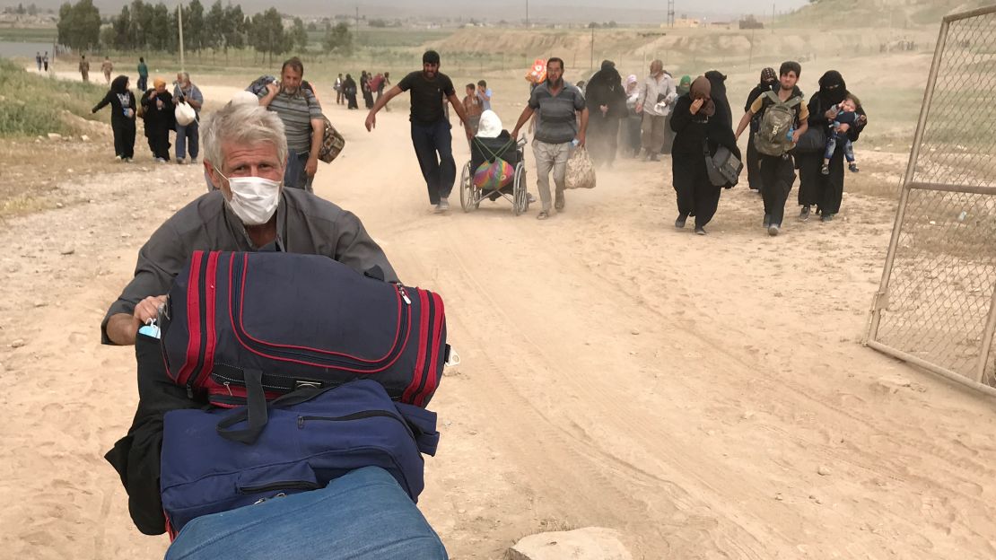 Resident from northwest Mosul pushes his belongings on a stroller as he flees fighting there. 