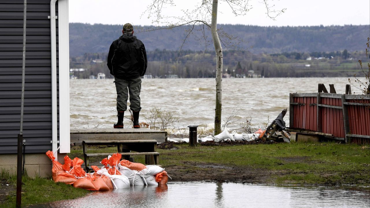 Steve Tousignant watches the Ottawa River from the deck of his home in Constance Bay, an Ottawa neighborhood, on Monday, May 8. Torrential rains and melting snow have caused flooding in various parts of Canada.