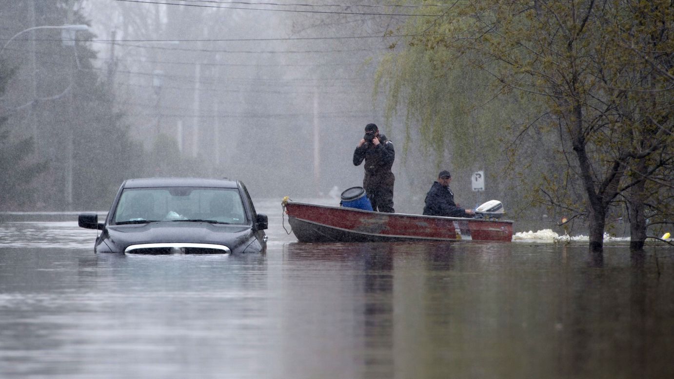 Two men pass a submerged truck in Gatineau, Quebec, on May 8. 
