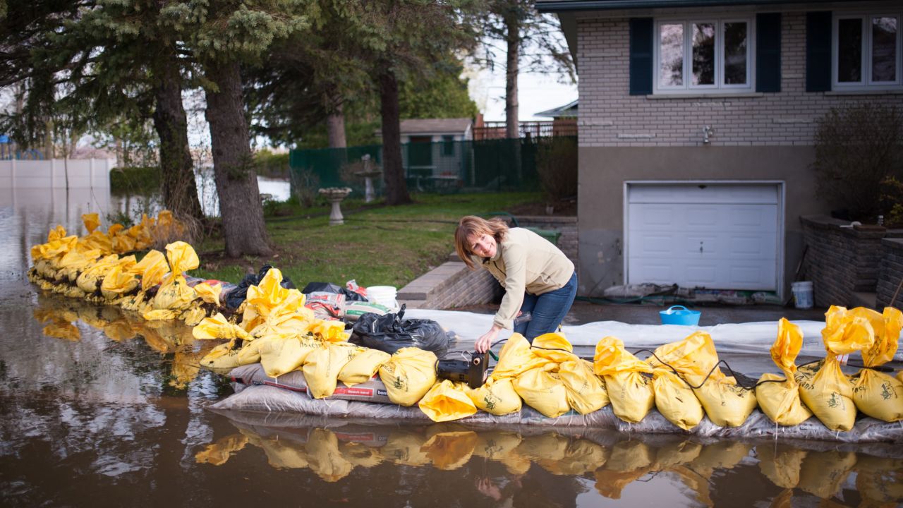 Johanne Aubin uses a pool pump to protect her Montreal home from floodwaters on May 8.