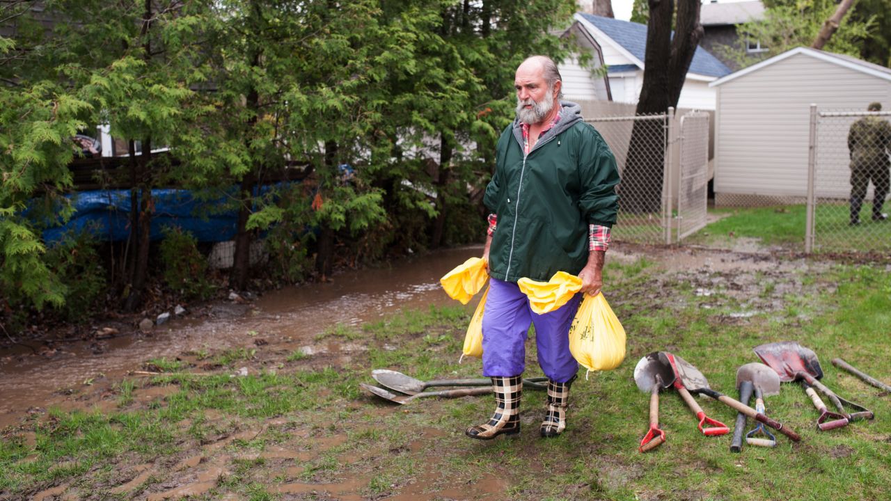 A man in Montreal carries sandbags on Sunday, May 7.