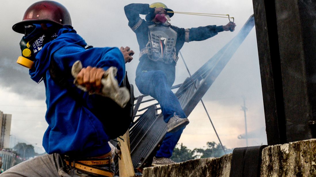 Opposition activists clash with riot police in Caracas on Monday, May 8. 