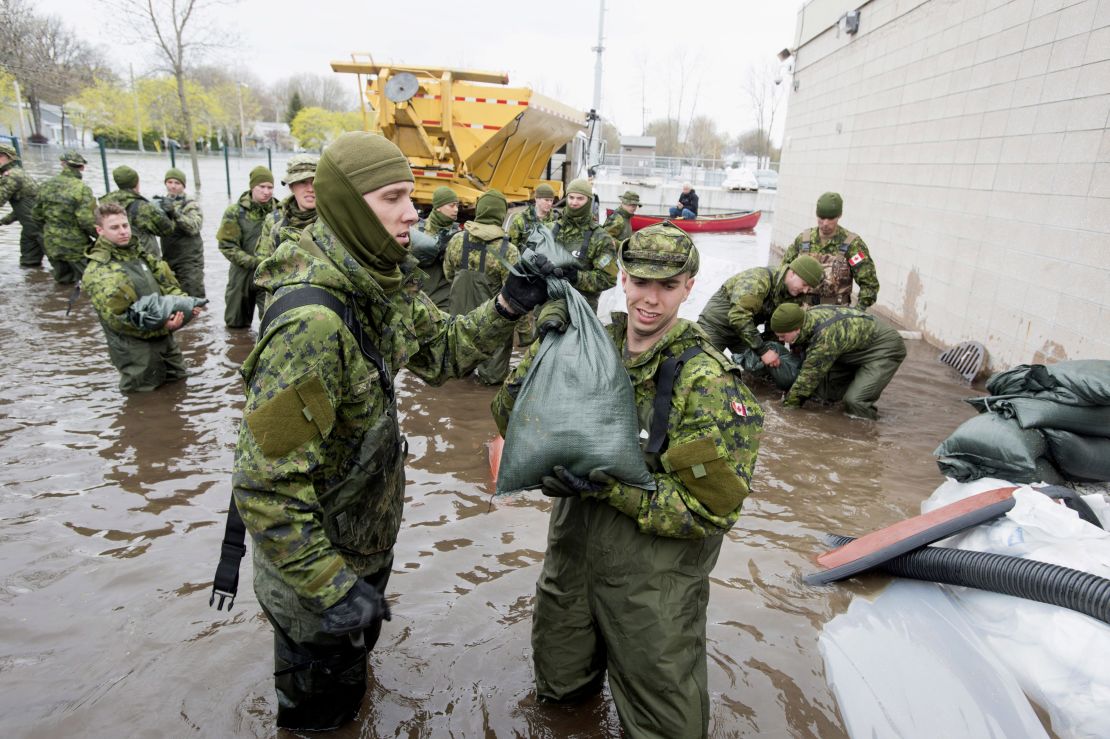 Canadian Forces personnel unload sandbags in Deux-Montagnes, Quebec. 
