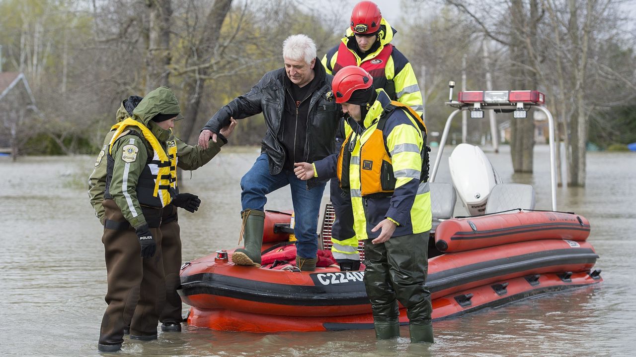 A man is assisted by Surete du Quebec police officers after being evacuated from his home in the town of Rigaud, Quebec.