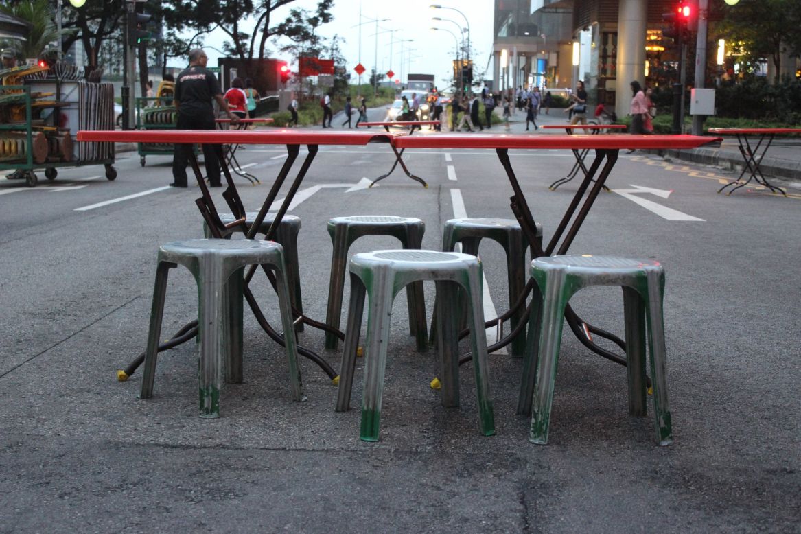 <strong>Street seats:</strong> Cars take a detour, while street food vendors set up tables and chairs in the street, choreographed like a Broadway production.