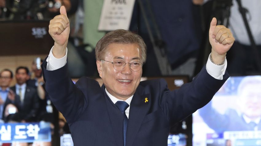 South Korea's presidential candidate Moon Jae-in of the Democratic Party raises his hands as his party leaders, members and supporters watch on television local media's results of exit polls for the presidential election at National Assembly in Seoul, South Korea, Tuesday, May 9, 2017. Exit polls forecast that liberal candidate Moon win the election Tuesday to succeed ousted President Park Geun-hye. (AP Photo/Lee Jin-man)