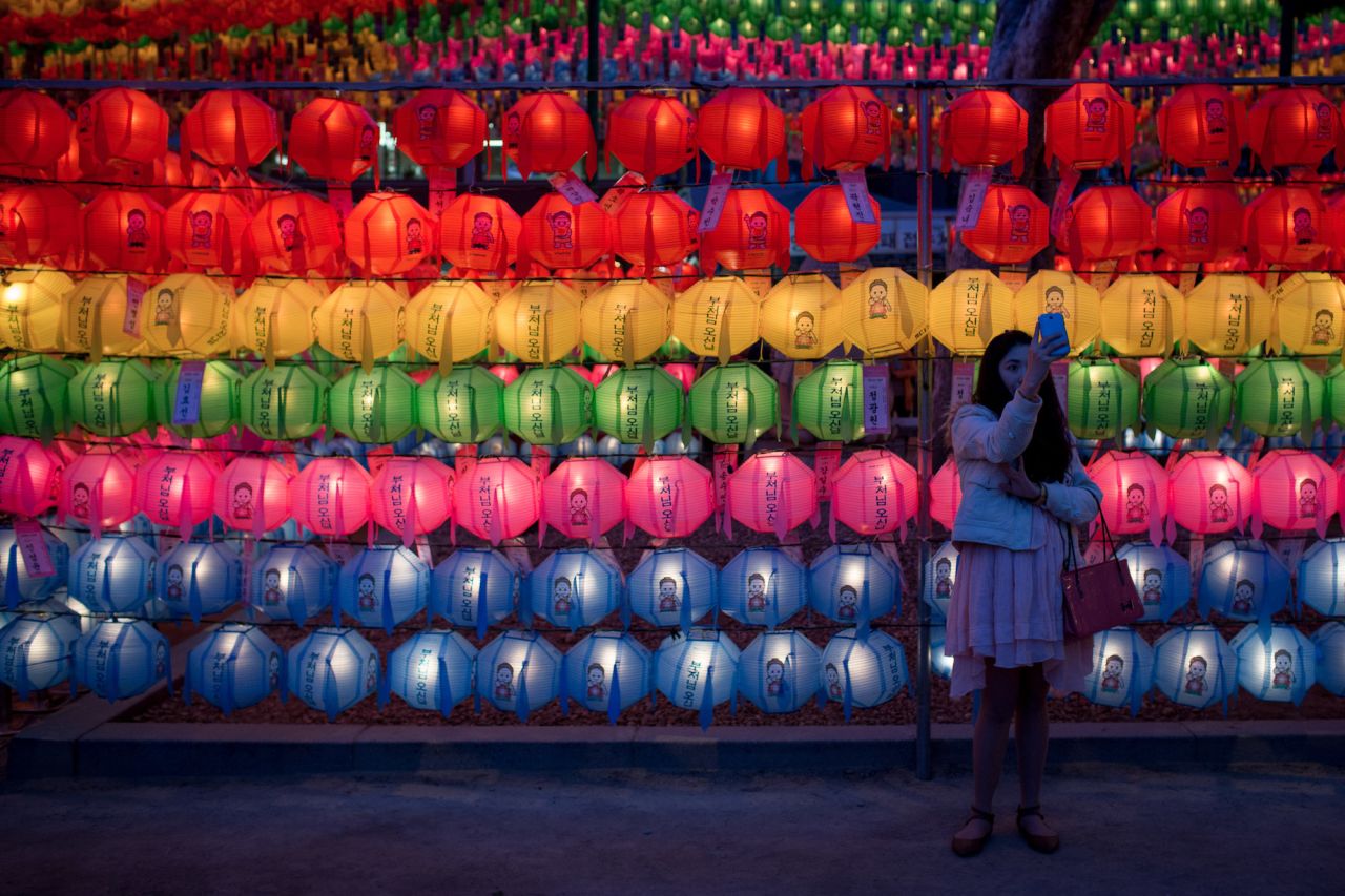 <strong>Seoul, South Korea: </strong>A woman takes a selfie in front of lines of lit lanterns during a past Vesak Day festival at Seoul's Jogyesa Temple, a popular site for Buddhists celebrating Buddha's birthday. 