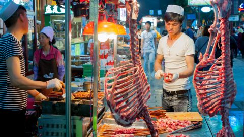 An ethnic Hui butcher carves lamb meat at the Muslim quarter in Xi'an.