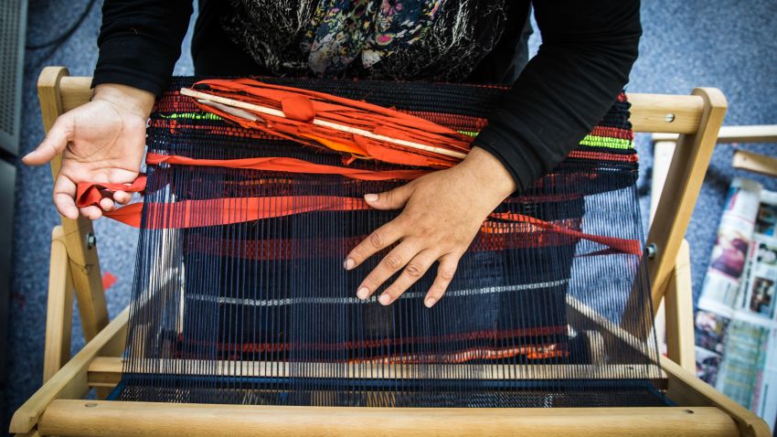 A weaver makes a welcome mat to sell for the Welcome Project, which raises money for female refugees