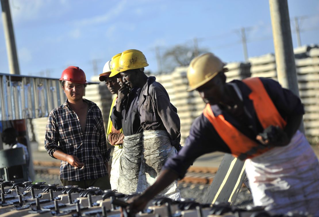 African, right, and Chinese workers, left, build railway track sections for the Mombasa-Nairobi Standard Gauge Railway (SGR) line in Tsavo, Kenya.