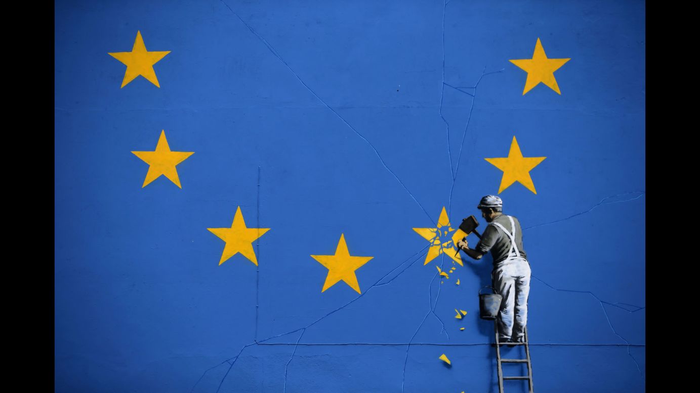 A mural in Dover, England -- recently painted by British graffiti artist Banksy -- depicts a worker chipping away at a European star on Monday, May 8.